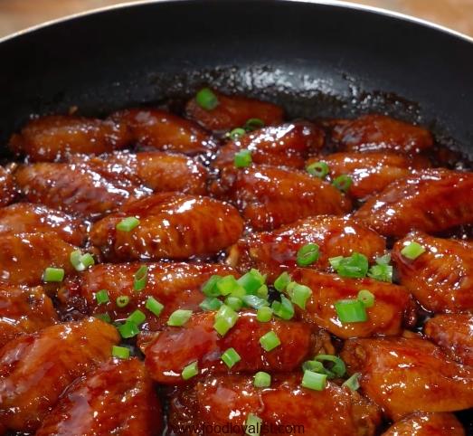Cook the chicken wings over high heat until the sauce is absorbed, sprinkle with chopped green onions and serve.
